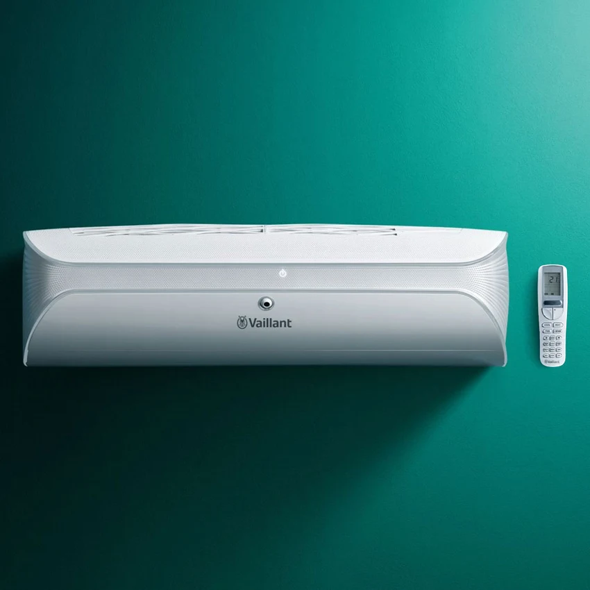 Immagine di un climatizzatore Vaillant CLIMA VAIH Premium da 9000 BTU, montato su una parete verde. Il design elegante e moderno dell'unità interna è evidenziato con un telecomando accanto.